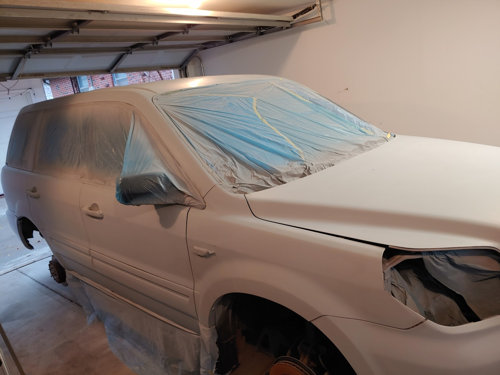 Full vehicle masked and primed in a garage